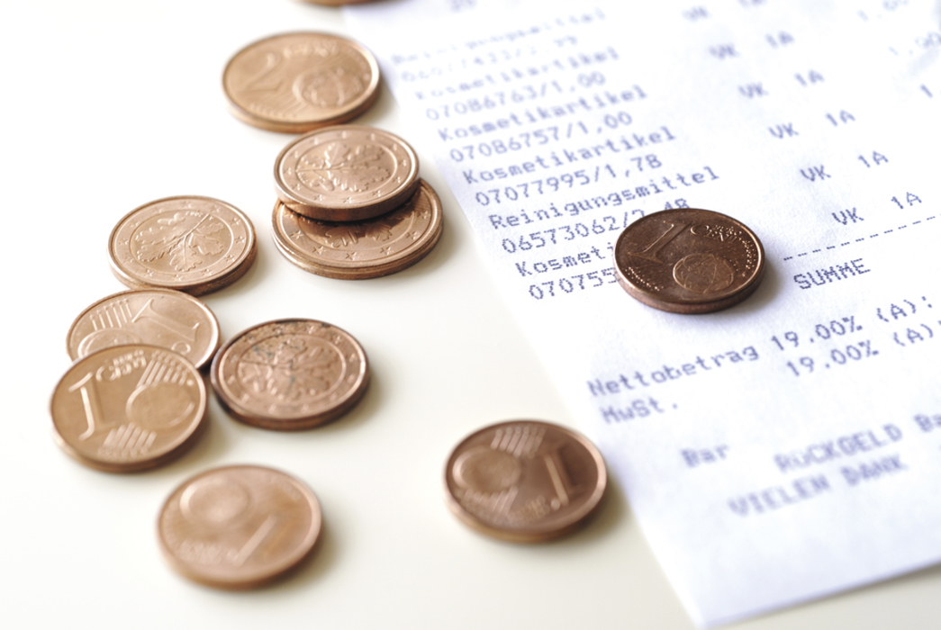 kassenzettel und einige ein und zwei cent münzen liegen auf einem tisch