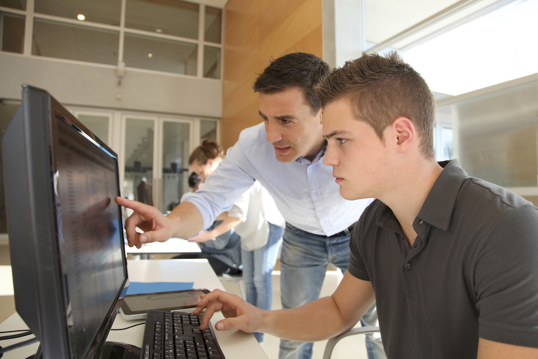 lehrer und schüler arbeiten am computer.