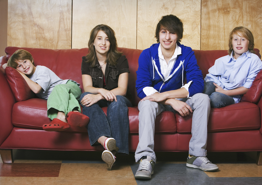 vier geschwister posieren auf einer couch
