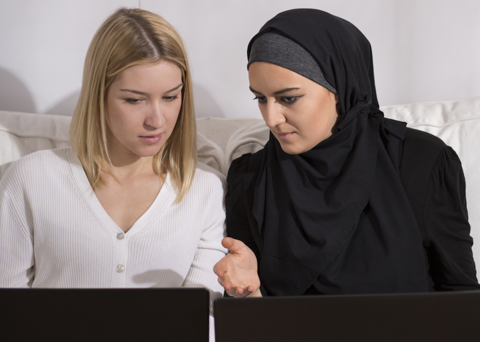 zwei frauen sitzen zusammen